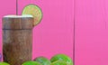 Tahiti lemon juice and fruits Citrus Ãâ latifolia in wooden cup on pink background